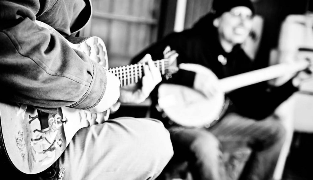 Two people playing guitar and banjo